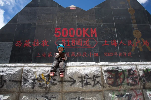 Дитина в передній від roadsign, Тибет — стокове фото