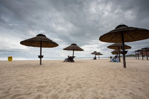 People sitting under wood made umbrellas on the beach of Sopot — Stock Photo, Image