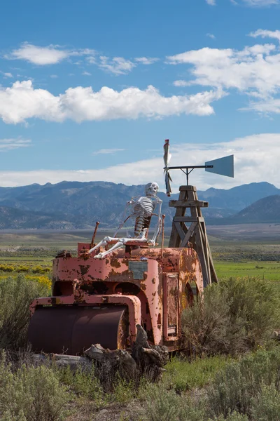 Skelet zittend op een vintage trekker in utah met bergen — Stockfoto