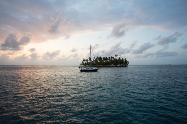 Sailing with beautiful sunset near paradise island, San Blas clipart
