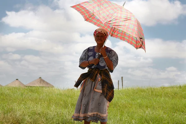 Südafrikanische Frau hält einen Regenschirm in der Hand, um sie vor dem — Stockfoto