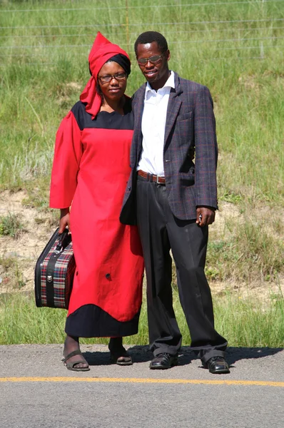 Modern South African couple staying by the road and posing to th