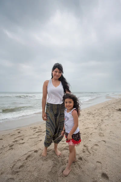 Matka s dcerou pózuje na pláži — Stock fotografie