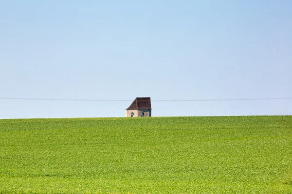 Erba verde, cielo blu e una piccola piccola vecchia casa — Foto Stock
