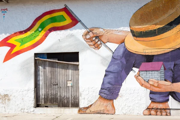 Людина з капелюх і будинок і Колумбійський прапор в його руках — стокове фото