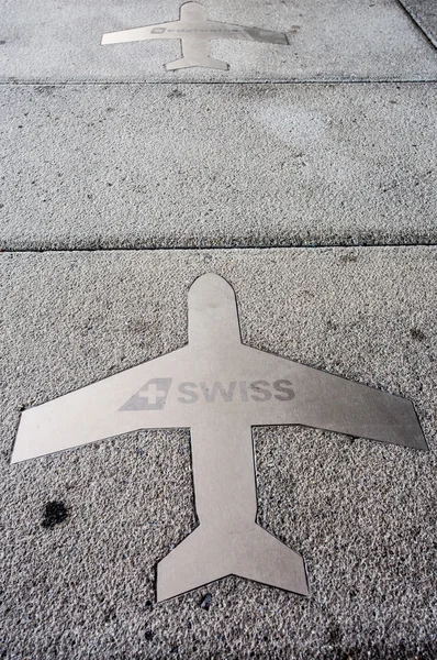 Silhouette d'un avion sur le sol avec la marque Swiss — Photo