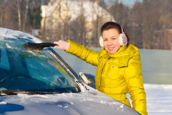 Menina limpeza carro da neve Fotografias De Stock Royalty-Free