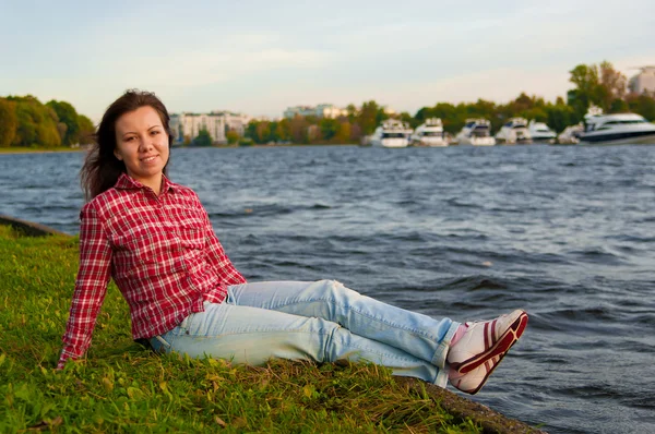 Dívka sedící blízko řeky — Stock fotografie