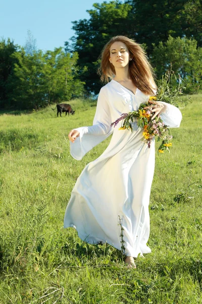 Vrouw lopen op het gras buitenshuis — Stockfoto