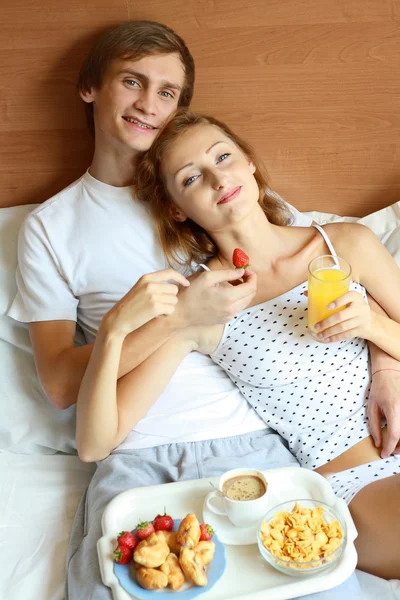 Jovem casal tomar café da manhã na cama — Fotografia de Stock