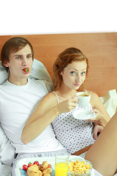 若いカップルはベッドで朝食をとる — ストック写真