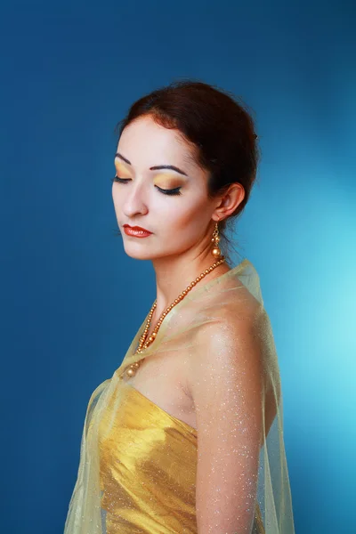 Asiatin im goldenen Kleid — Stockfoto