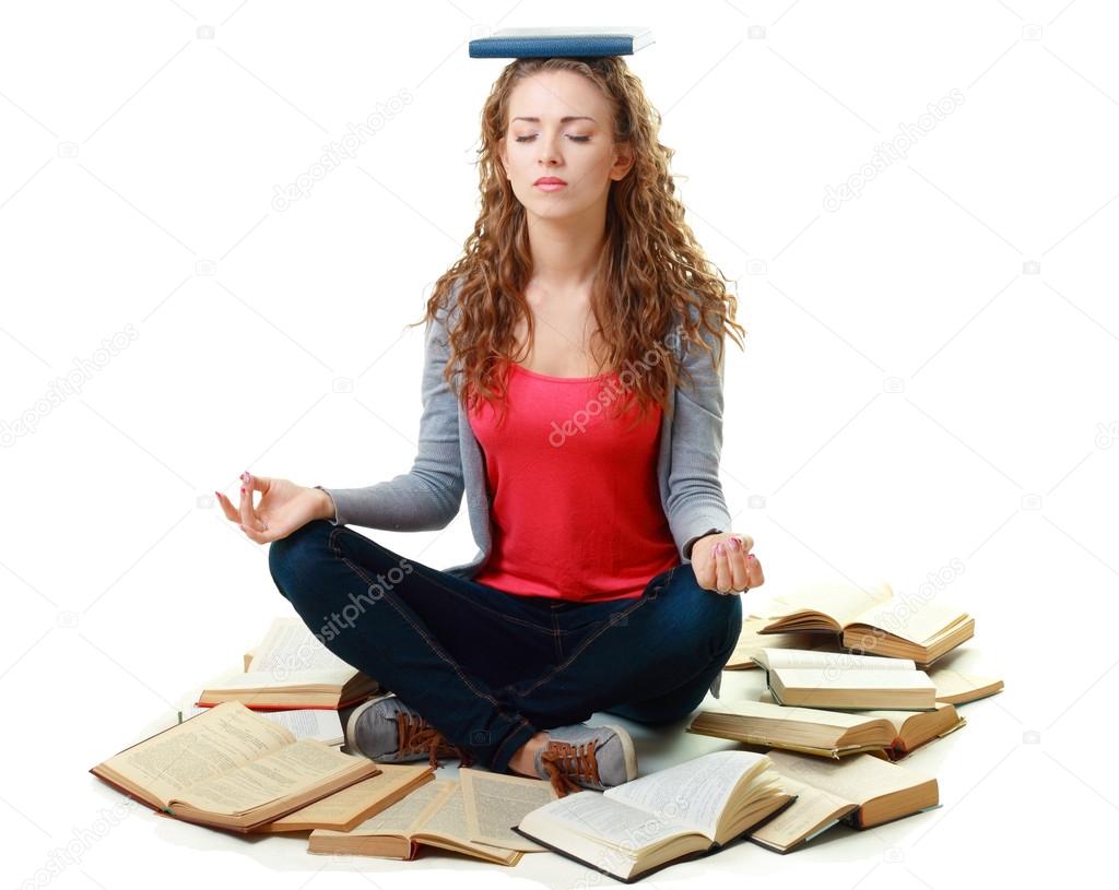 Student girl sitting and meditating with books