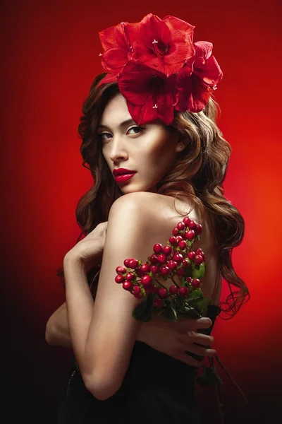Woman with red flowers in hair — Stock Photo, Image