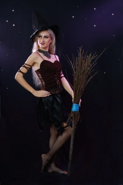 Krásná čarodějka drží koště — Stock fotografie