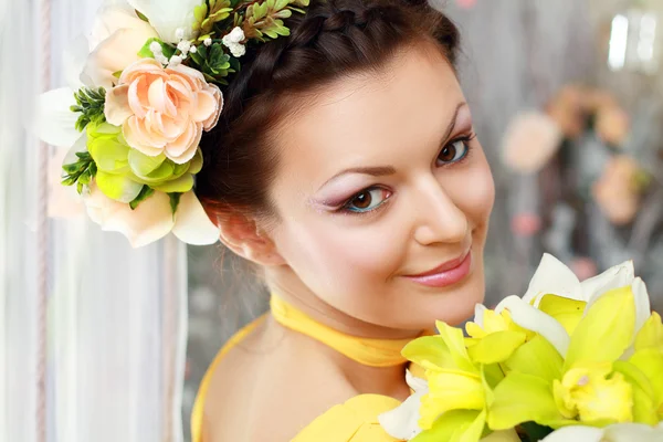 Meisje met stijlvolle make-up en bloemen — Stockfoto