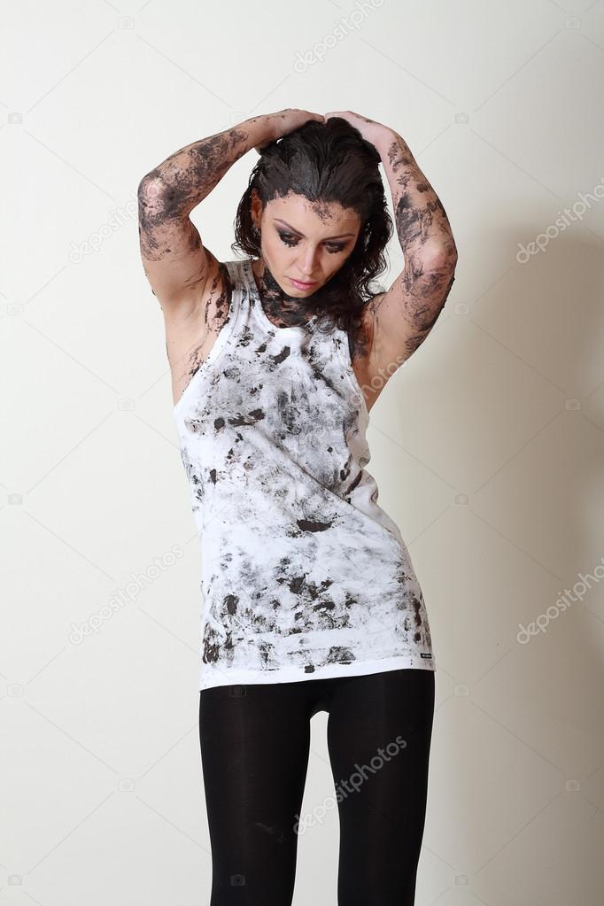 woman with face and body covered in mud