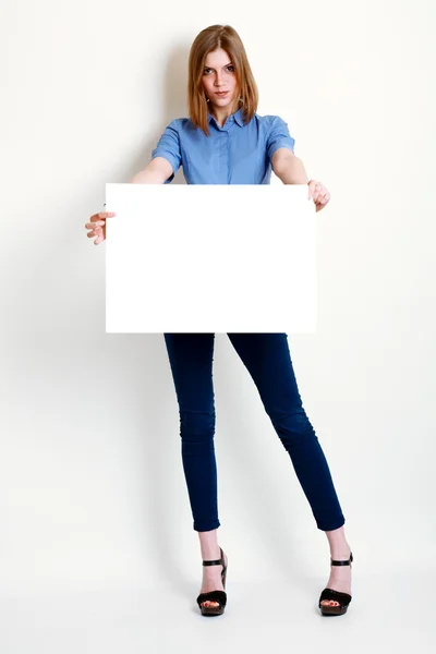 Woman holds out a big blank card — Stock Photo, Image