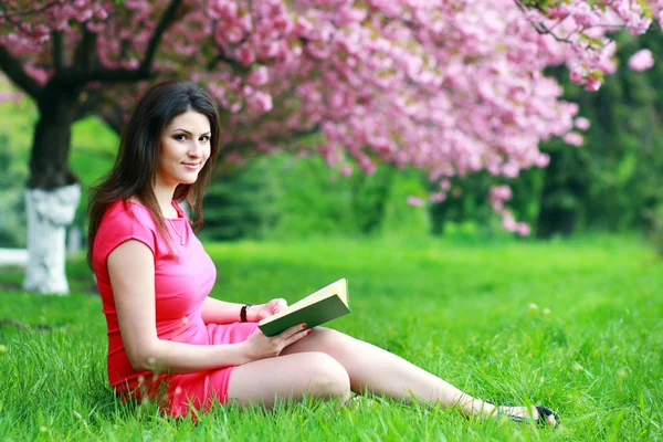 Vrouw zitten op een gras — Stockfoto