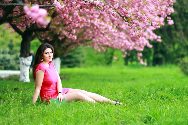 Женщина, сидящая на траве — стоковое фото