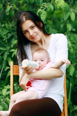 Anne bebeğini besleyen