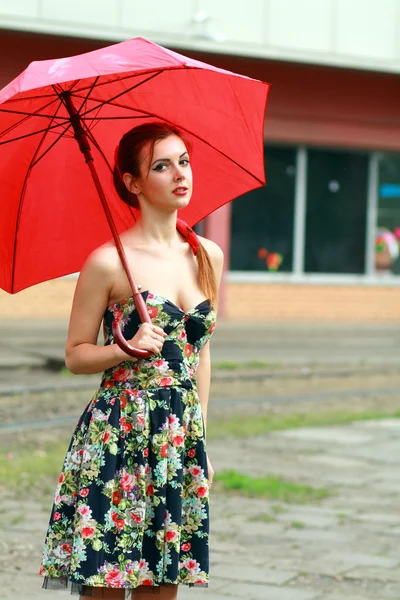 Mulher segurando um guarda-chuva vermelho — Fotografia de Stock