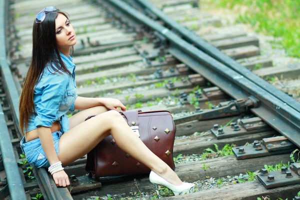 Mooie dame zitten op de rails — Stockfoto