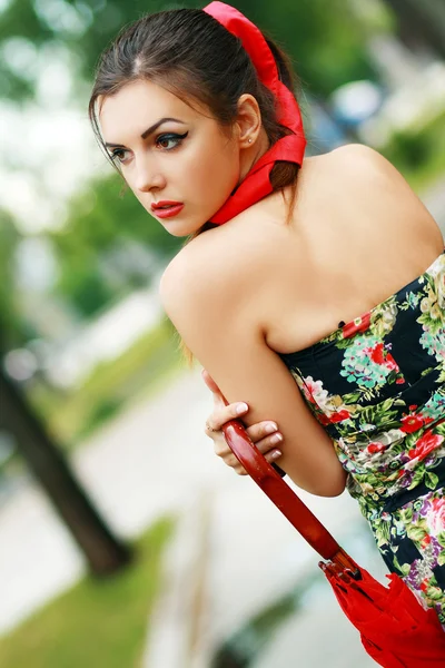 Mujer sosteniendo un paraguas rojo — Foto de Stock