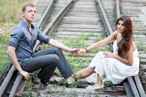 Couple sitting on railway — Stock Photo, Image