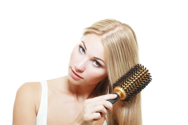 Blonde junge Bürsten ihre Haare — Stockfoto