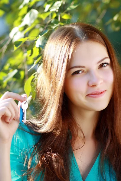 Frau hält Schlüssel hoch — Stockfoto