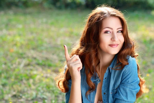 Sourire jeune femme pointant du doigt — Photo