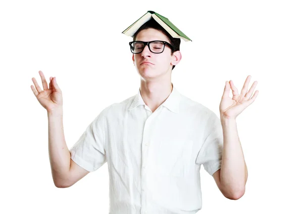 Student meditates with book on his head — Stock Photo, Image