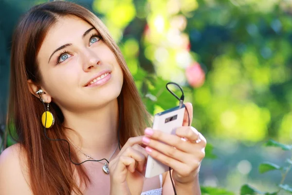 Jonge vrouw met behulp van een smartphone te luisteren naar muziek — Stockfoto