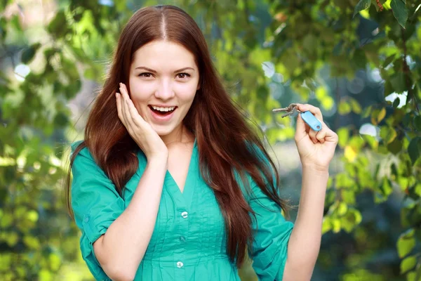 Frau hält Schlüssel hoch — Stockfoto