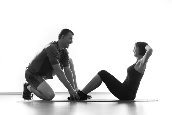 Kvinnan gör situps med coach — Stockfoto