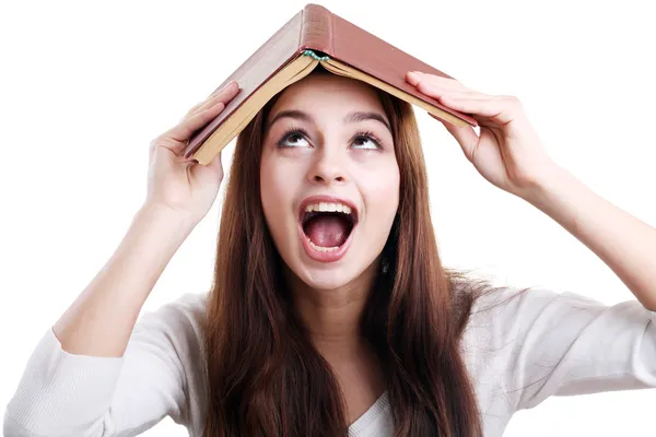 Meisje met boek over haar hoofd — Stockfoto