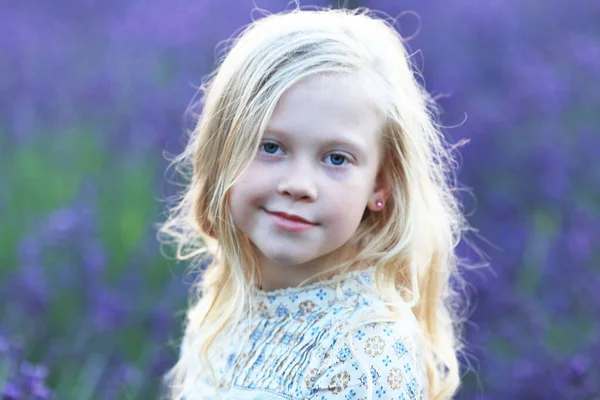 Blond Liten Flicka Porträtt Tittar Kameran Violetta Blommor Äng — Stockfoto