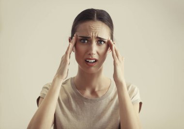 Portrait of terrified woman with blond hair posing next to color background