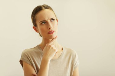 Güzel, düşünceli, sarı saçlı bir kadının portresi. Renkli arka planda poz veriyor.