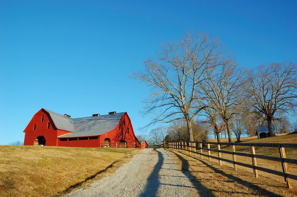 Granero rojo brillante bajo un gran cielo azul - Una escena pastoral americana Imágenes De Stock Sin Royalties Gratis