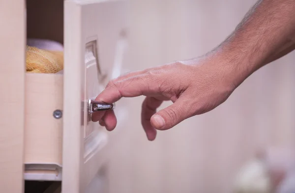 Hand opens a cupboard — Stock Photo, Image