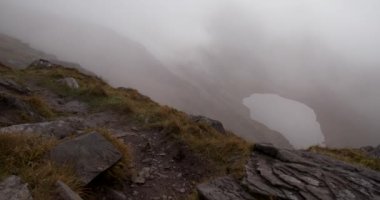 Dağ Vadisi 'nin hareketli bulutlar ve sisli zorlu hava koşullarında geçen 4K dramatik videosu, McGillycuddy Reeks, Killarney, Kerry, İrlanda