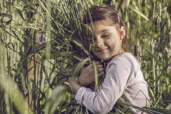 Girl tenderly embraces sheaf of wheat — Stock Photo, Image