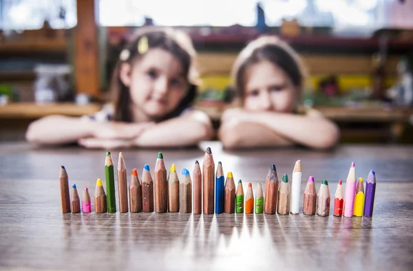 Bambini e matite allineati in fila Fotografia Stock
