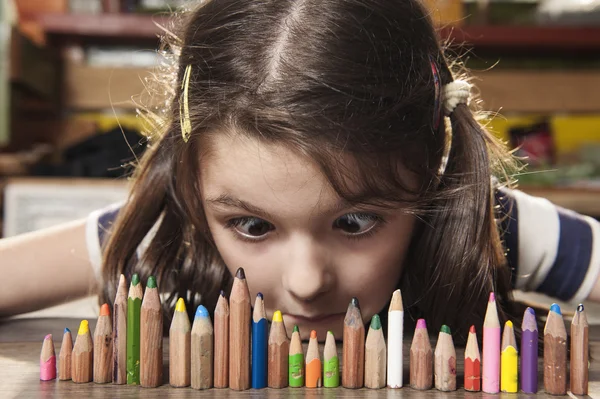 Menina mais inteligente olhando para lápis — Fotografia de Stock