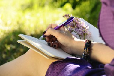 defter, kalem ve erkek eli yakın, park