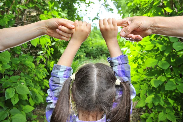 Mother and father holding hands his daughter — Stock Photo, Image