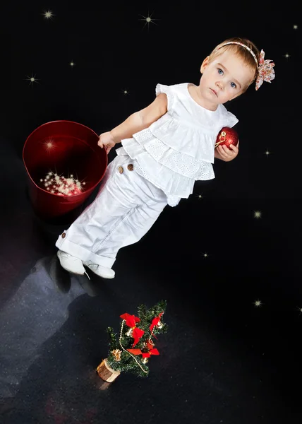 Bella bambina che gioca con i giocattoli di Natale, sfondo blu — Foto Stock