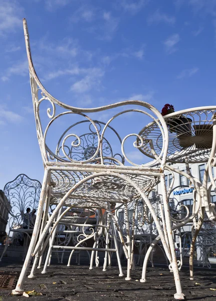 Street cafe with white metal tables and chairs